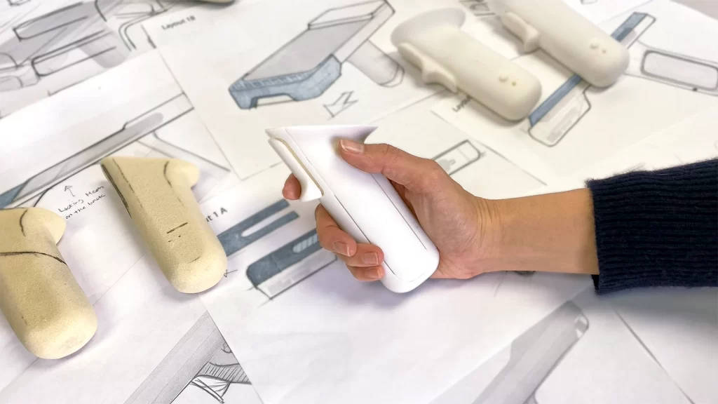  Image of a StudioRed designer holding a handle prototype for the Fulfilld warehouse scanner. 